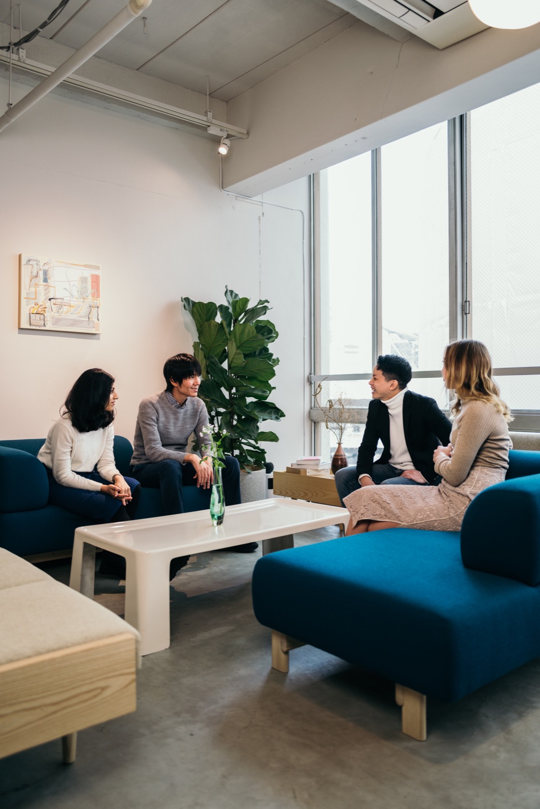 Colleagues in conversation in a sunlit lounge